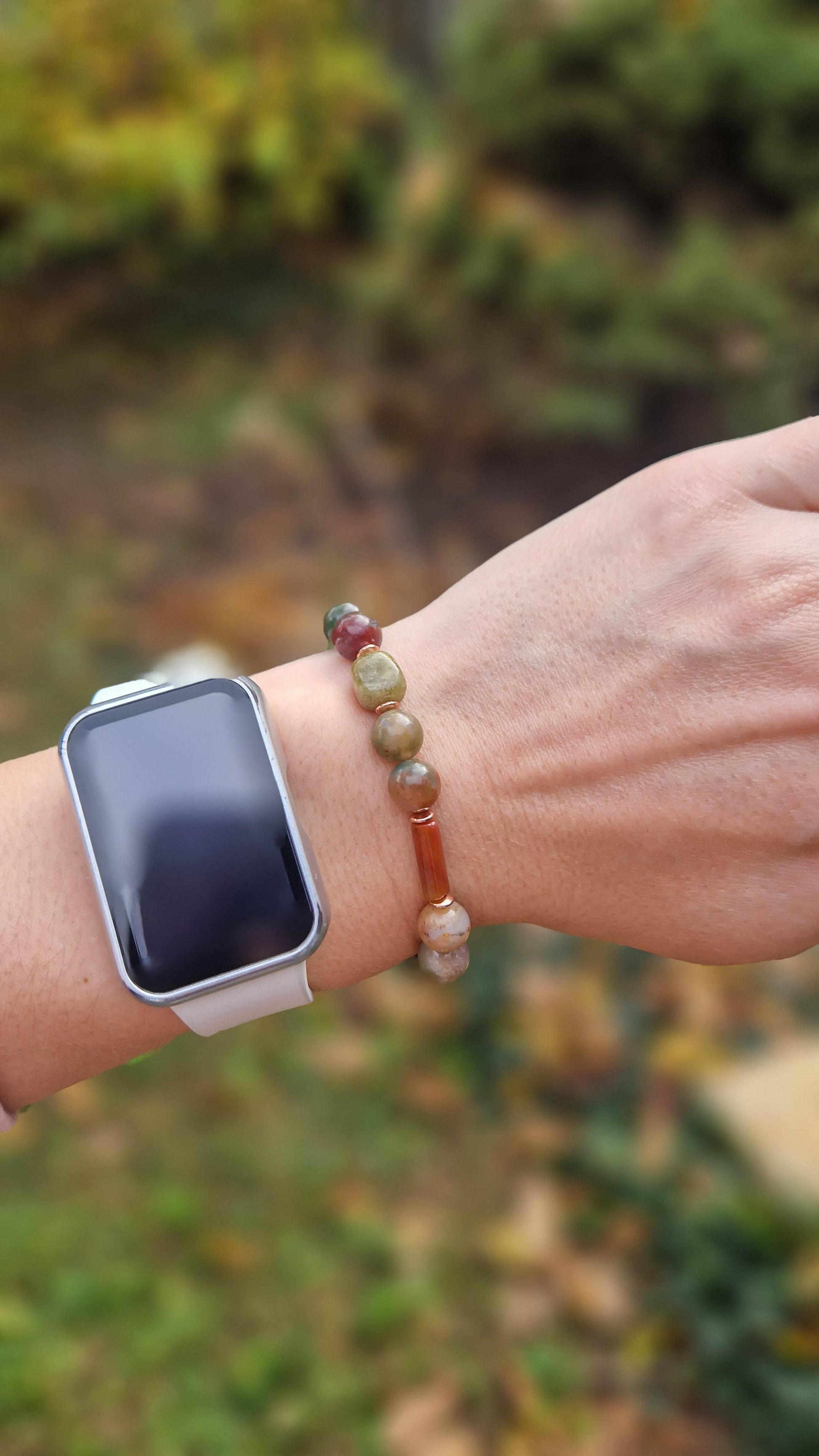 egyedi női karkötő indiai achát és gránát grossulat ásványokkal, indiai achát hasábbal, valamint rosegold hematatit köztessel, természtes fa háttérrel