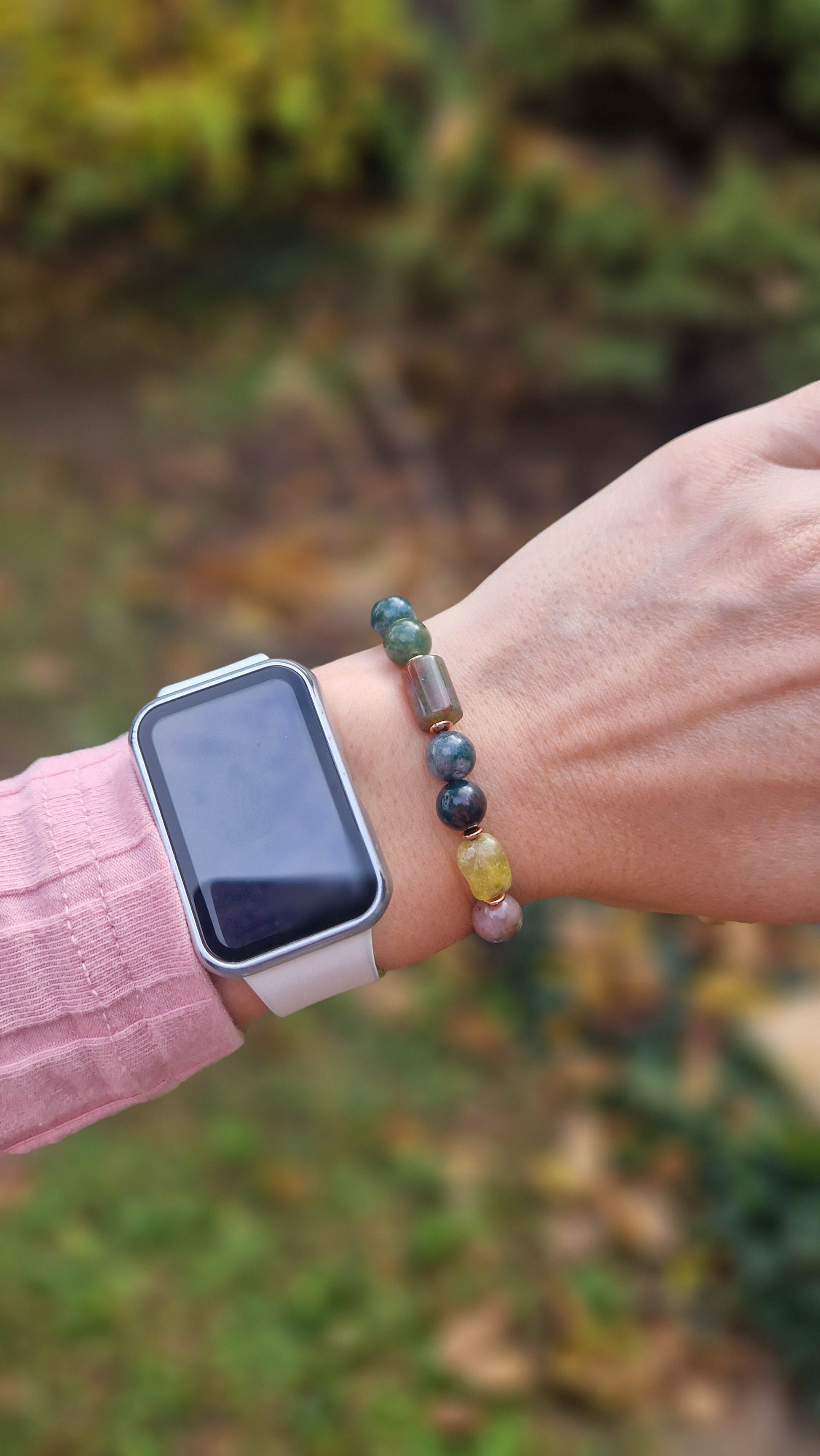 egyedi női karkötő indiai achát és gránát grossulat ásványokkal, indiai achát hasábbal, valamint rosegold hematatit köztessel, természtes fa háttérrel