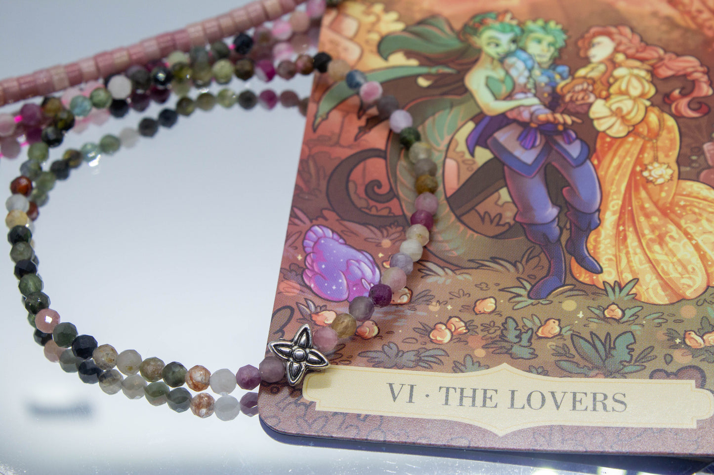 4 mm-es turmalinból készült ásványkarkötő, középen egy virág charmmal, februári spirituális ásványkarkötő