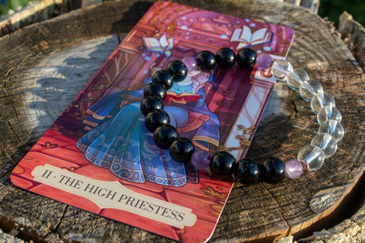 Kézzel készült tarot ihlette ásvány karkötő ónix, ametiszt és hegyikristály felhasználásával. A Főpapnő energiája intuíciót, belső harmóniát és lelki tisztánlátást támogat.